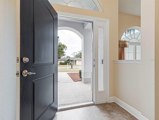 foyer entrance featuring light colored carpet