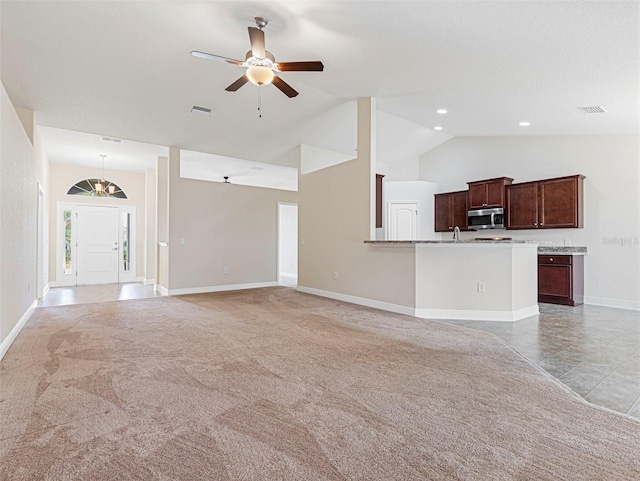 unfurnished living room with ceiling fan, light colored carpet, and lofted ceiling