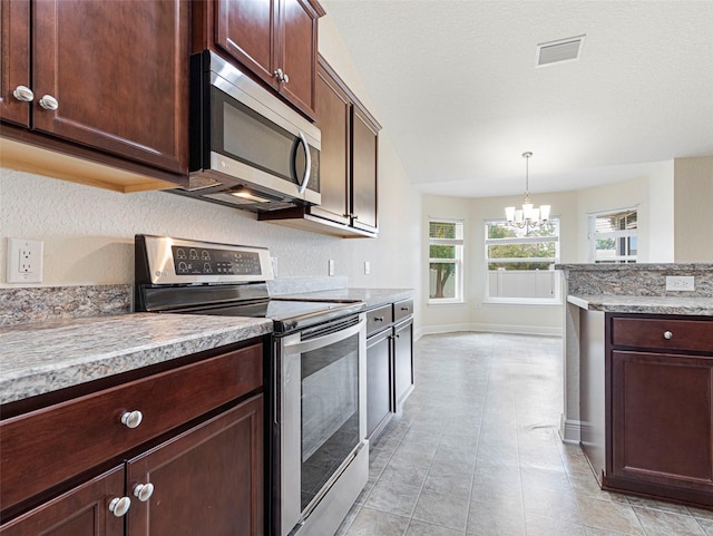 kitchen with pendant lighting, stainless steel appliances, a chandelier, and light stone counters