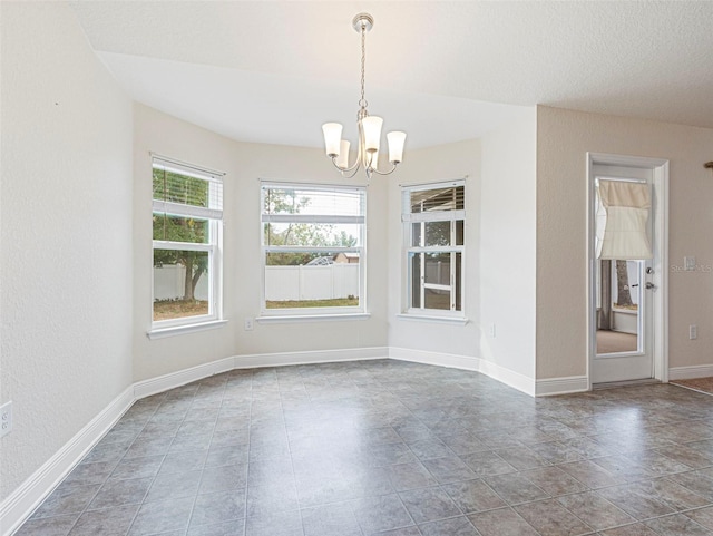 unfurnished dining area with an inviting chandelier