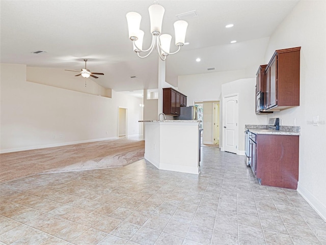 kitchen with appliances with stainless steel finishes, ceiling fan with notable chandelier, light tile patterned floors, lofted ceiling, and pendant lighting