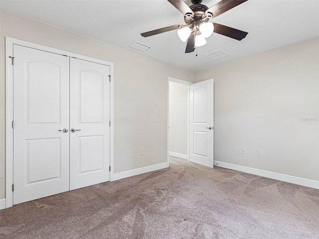 unfurnished bedroom with light colored carpet, ceiling fan, and a closet