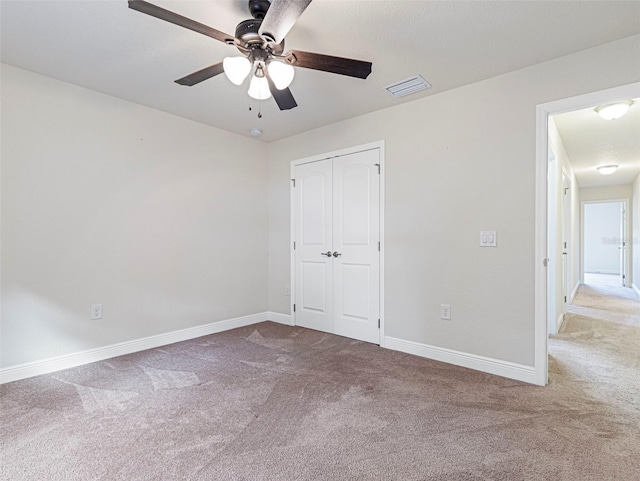 unfurnished bedroom featuring carpet floors, ceiling fan, and a closet