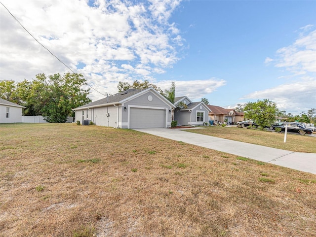 ranch-style house featuring a garage, cooling unit, and a front lawn