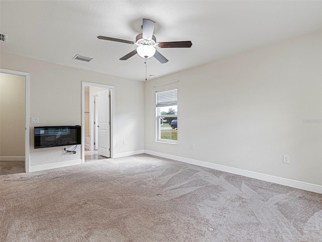 carpeted empty room with ceiling fan and heating unit