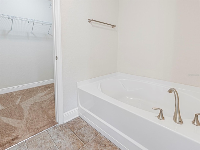 bathroom with a washtub and tile patterned flooring