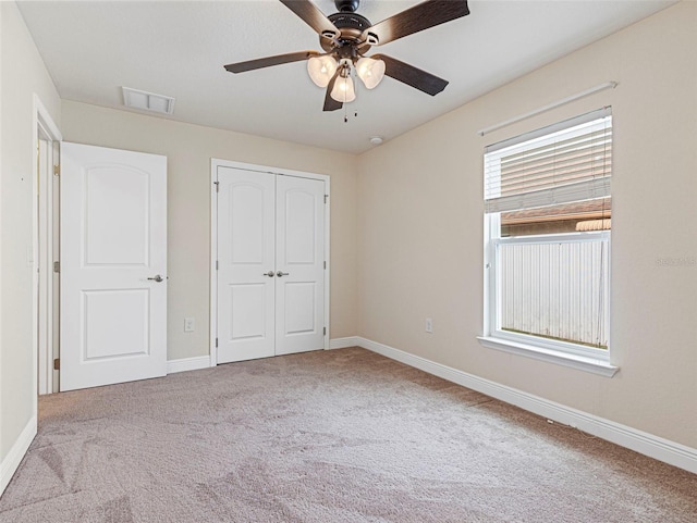 unfurnished bedroom featuring a closet, light carpet, and ceiling fan