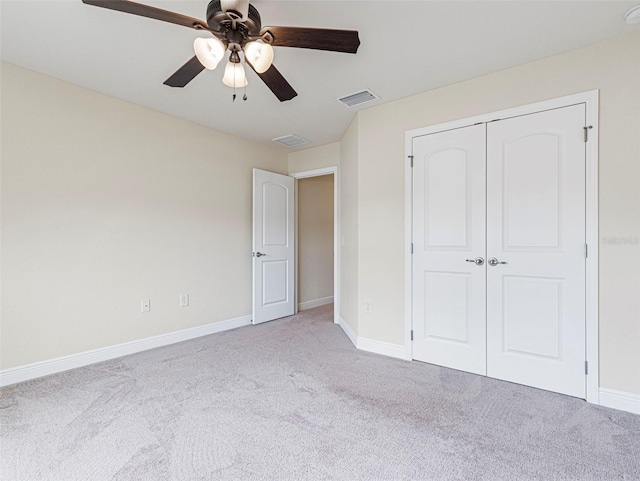 unfurnished bedroom featuring ceiling fan, a closet, and light colored carpet