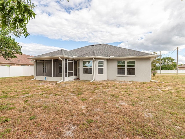 back of property featuring a sunroom and a yard