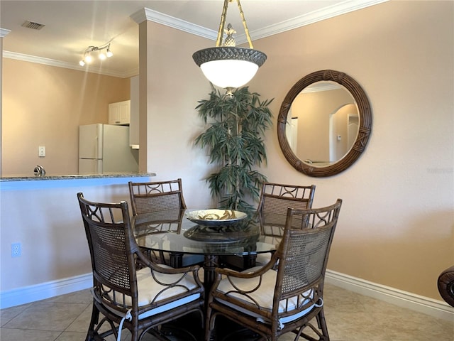 dining room featuring ornamental molding and light tile patterned floors