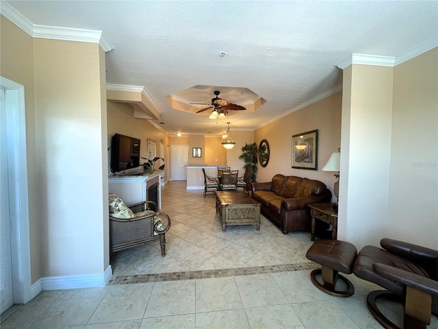 living room with crown molding, a tray ceiling, and ceiling fan