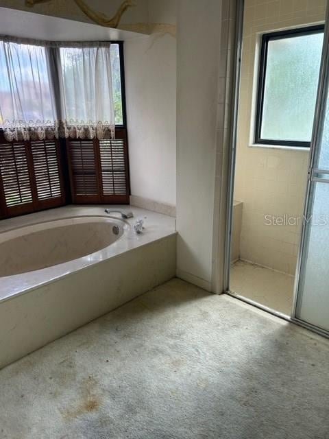 bathroom featuring shower with separate bathtub