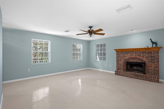 unfurnished living room featuring ceiling fan and a brick fireplace