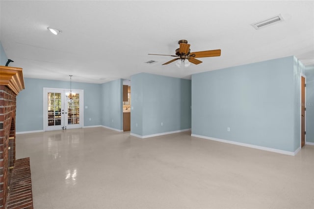 unfurnished living room featuring ceiling fan with notable chandelier and a brick fireplace