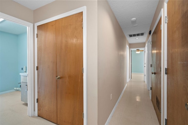 hall featuring a textured ceiling