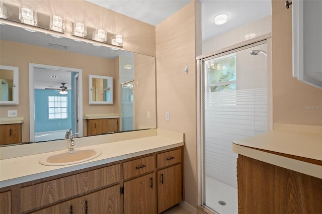 bathroom with vanity, ceiling fan, and walk in shower