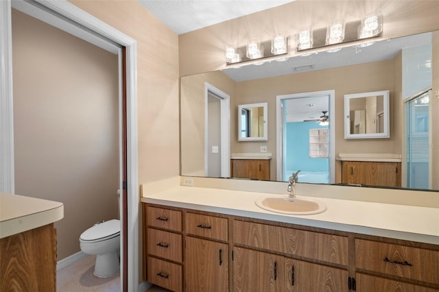 bathroom featuring vanity, an enclosed shower, toilet, and ceiling fan