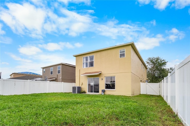 back of property with cooling unit and a yard