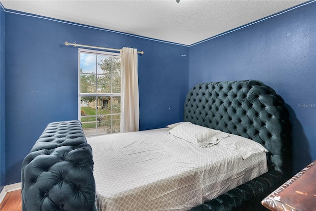 bedroom featuring a textured ceiling and hardwood / wood-style flooring