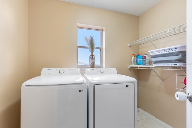 laundry room featuring washing machine and clothes dryer and light tile patterned flooring