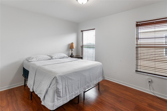 bedroom with dark hardwood / wood-style flooring