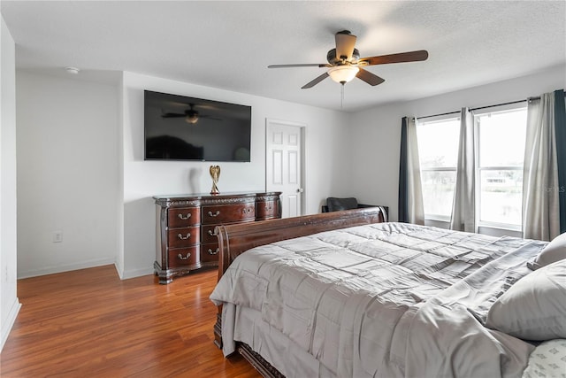 bedroom featuring hardwood / wood-style floors, ceiling fan, and a textured ceiling