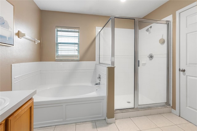 bathroom featuring shower with separate bathtub, vanity, and tile patterned floors