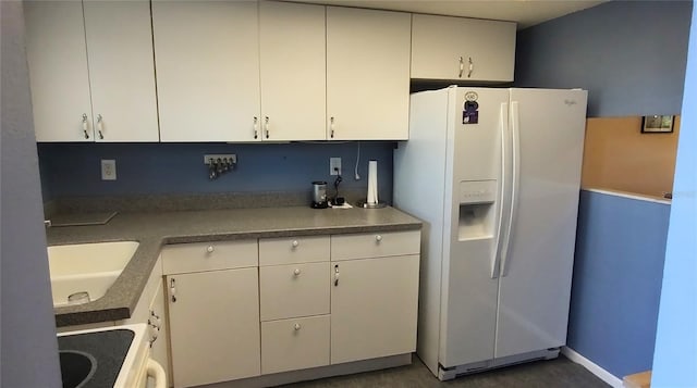 kitchen with white refrigerator with ice dispenser, stove, white cabinets, and sink