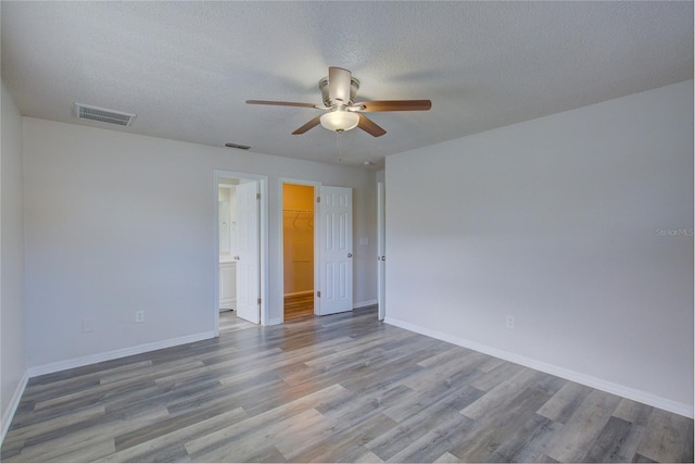 empty room with a textured ceiling and light wood-type flooring