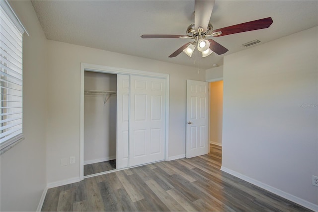 unfurnished bedroom featuring hardwood / wood-style floors, a textured ceiling, a closet, and ceiling fan