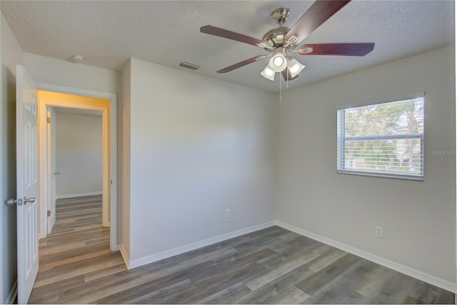 spare room with a textured ceiling, dark hardwood / wood-style floors, and ceiling fan