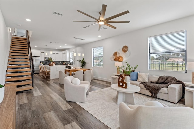 living room with a healthy amount of sunlight, light wood-type flooring, and ceiling fan