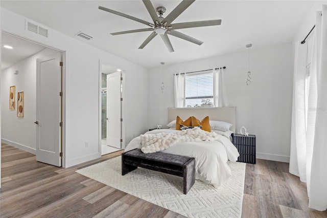 bedroom featuring hardwood / wood-style floors, ensuite bathroom, and ceiling fan