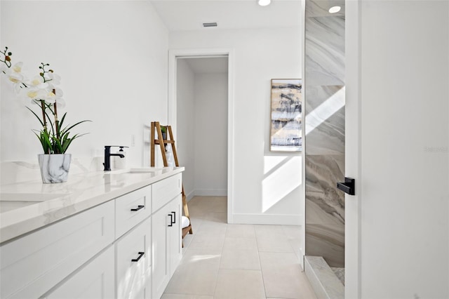 bathroom featuring vanity, tiled shower, and tile patterned flooring