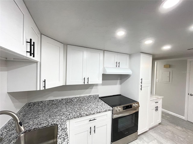 kitchen with stainless steel electric stove, white cabinets, and sink