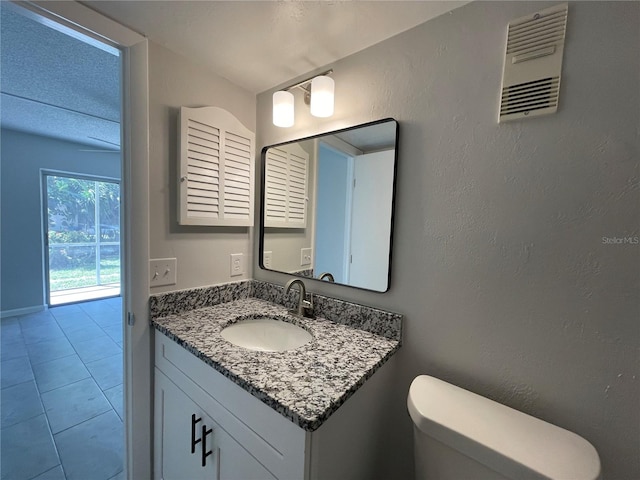 bathroom with tile patterned flooring, vanity, and toilet