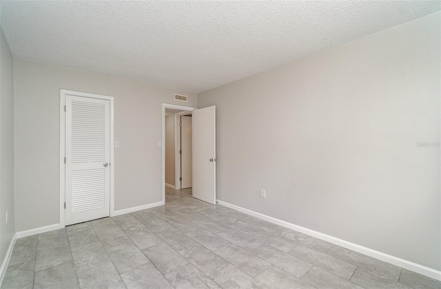 unfurnished bedroom featuring a closet and a textured ceiling