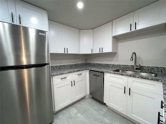 kitchen featuring white cabinets, sink, appliances with stainless steel finishes, and dark stone counters