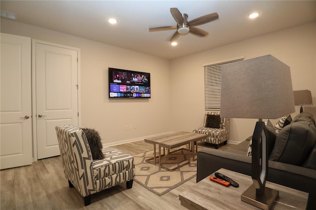 living room featuring light hardwood / wood-style flooring and ceiling fan