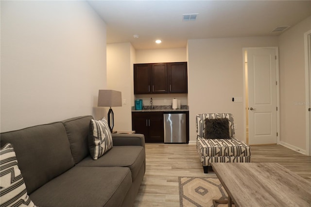 living room featuring sink and light hardwood / wood-style flooring