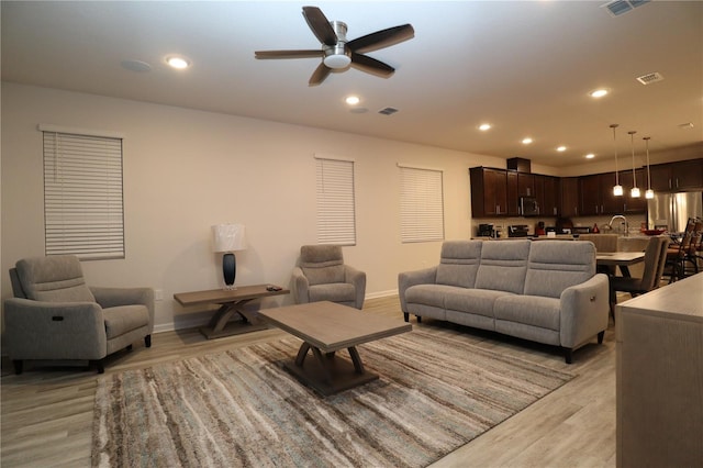 living room featuring light hardwood / wood-style floors and ceiling fan