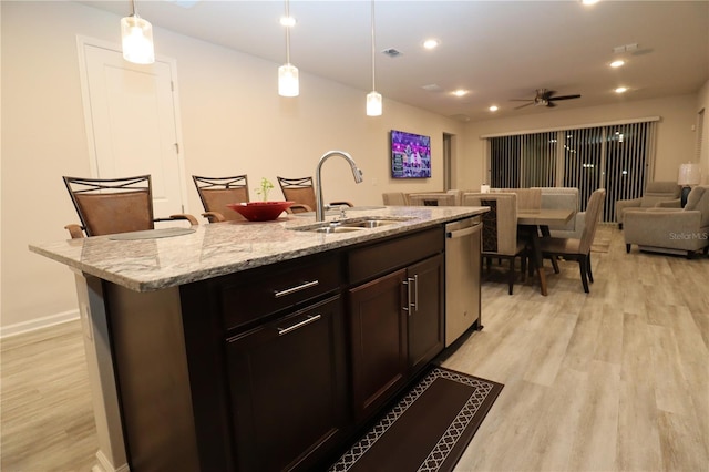 kitchen with pendant lighting, sink, a kitchen island with sink, and dishwasher