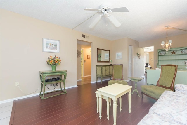 315 30th Ave W Unit B201, Bradenton, FL 34205 - living area featuring dark wood-style flooring, a ceiling fan, a chandelier, baseboards, and a textured ceiling