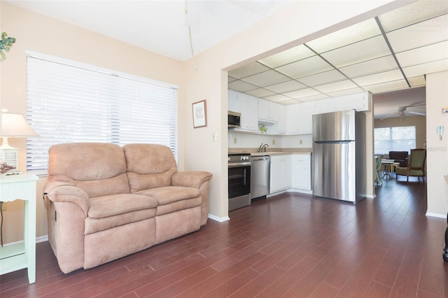 315 30th Ave W Unit B201, Bradenton, FL 34205 - living room with dark wood-style floors, ceiling fan, a paneled ceiling, and baseboards