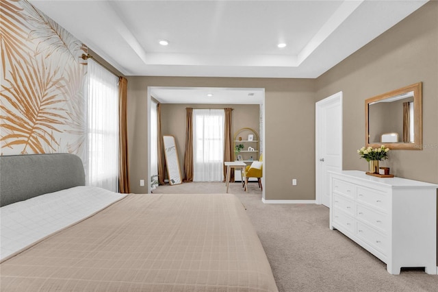 bedroom featuring a tray ceiling and light colored carpet