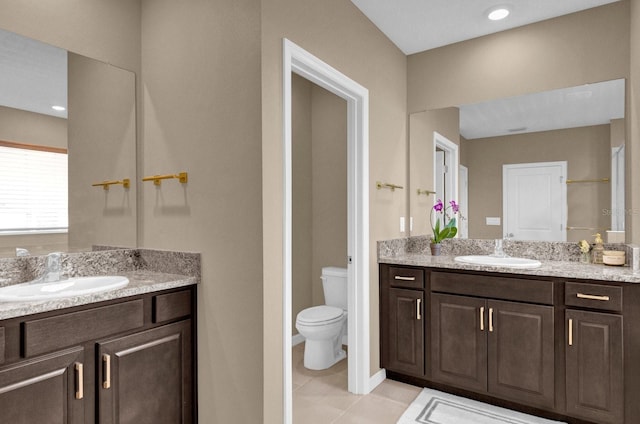 bathroom featuring toilet, vanity, and tile patterned flooring