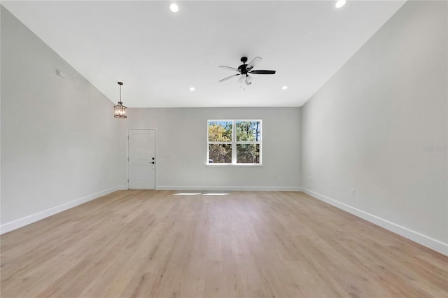 unfurnished living room featuring light hardwood / wood-style floors and ceiling fan with notable chandelier