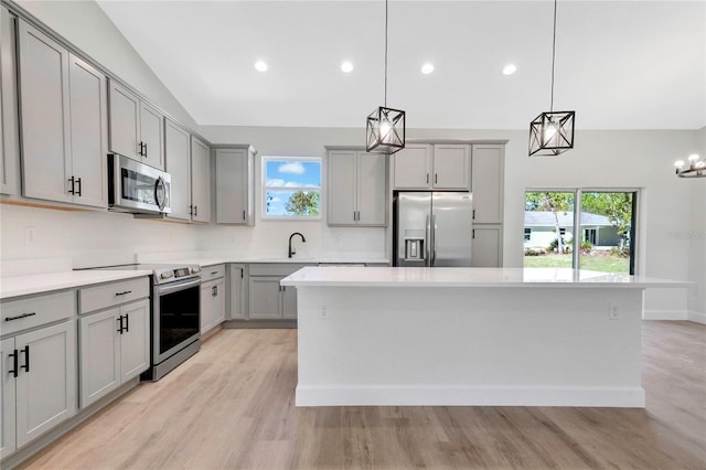 kitchen featuring a center island, appliances with stainless steel finishes, pendant lighting, and plenty of natural light