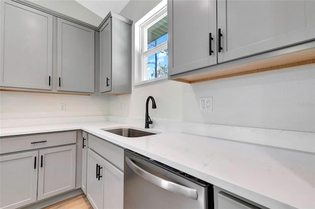 kitchen featuring light hardwood / wood-style flooring, sink, light stone countertops, gray cabinets, and stainless steel dishwasher