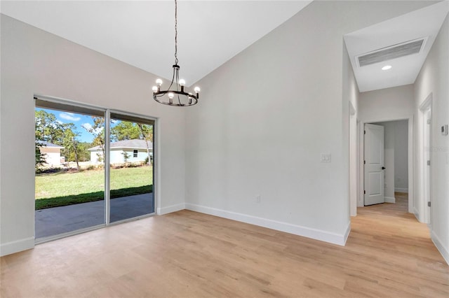 unfurnished room with light hardwood / wood-style floors and a chandelier